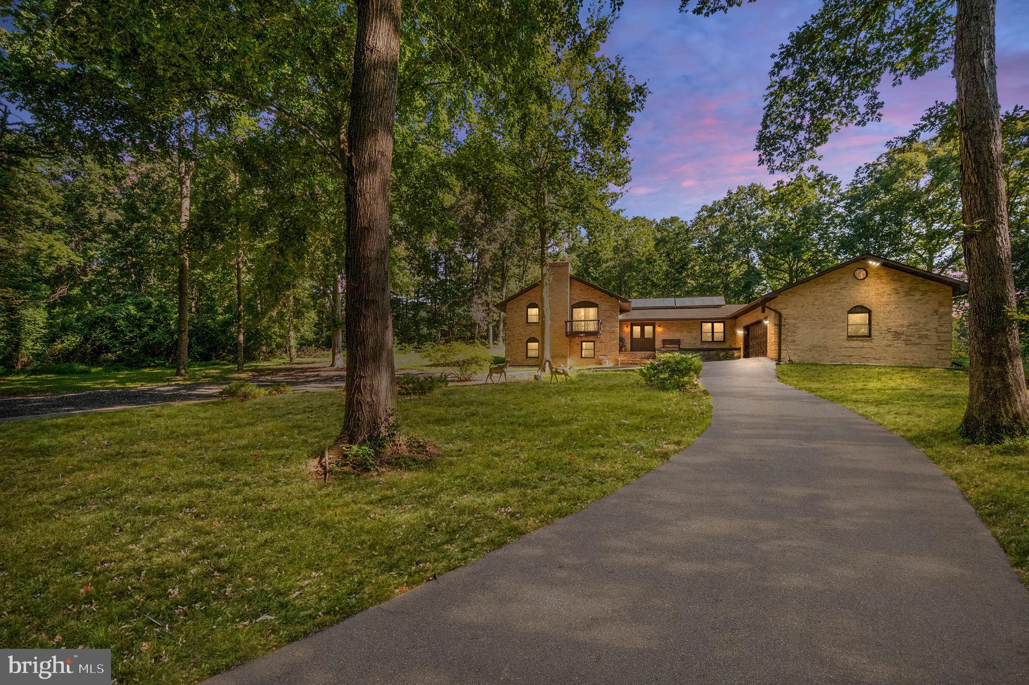This One-of-a-kind stunning all Brick home is surrounded by beautiful hardwoods and water views of Quantico creek.  Zoned Agricultural with multi purpose use on two private park-like acres with No HOA! The long concrete circular driveway has ample parking for 20+ cars and can house all your commercial & recreational vehicles, boats and more! Plus, there's an attached 2 1/2 garage. This desirable location is minutes to all the conveniences you need such as Rte. 1, I-95, and shopping.  The 600+ sq.ft renovated kitchen with adjoining dining area is the perfect entertaining space.  It features a huge kitchen island with granite countertops, upgraded cabinetry, newer appliances, built-in cabinet for your coffee bar, and tons of lighting. This 4-level home includes two living spaces so there's plenty of room for everyone.  You'll love all the modern touches throughout from the stair railings, light fixtures, and 2 electric fireplaces.  Large and Updated bathrooms with tile surround and soaker tub to relax in.  Extra room in the basement can be used as a 4th bedroom (NTC). And there are so many possibilities with the enclosed pool area.  Home is available fully furnished with acceptable offer.