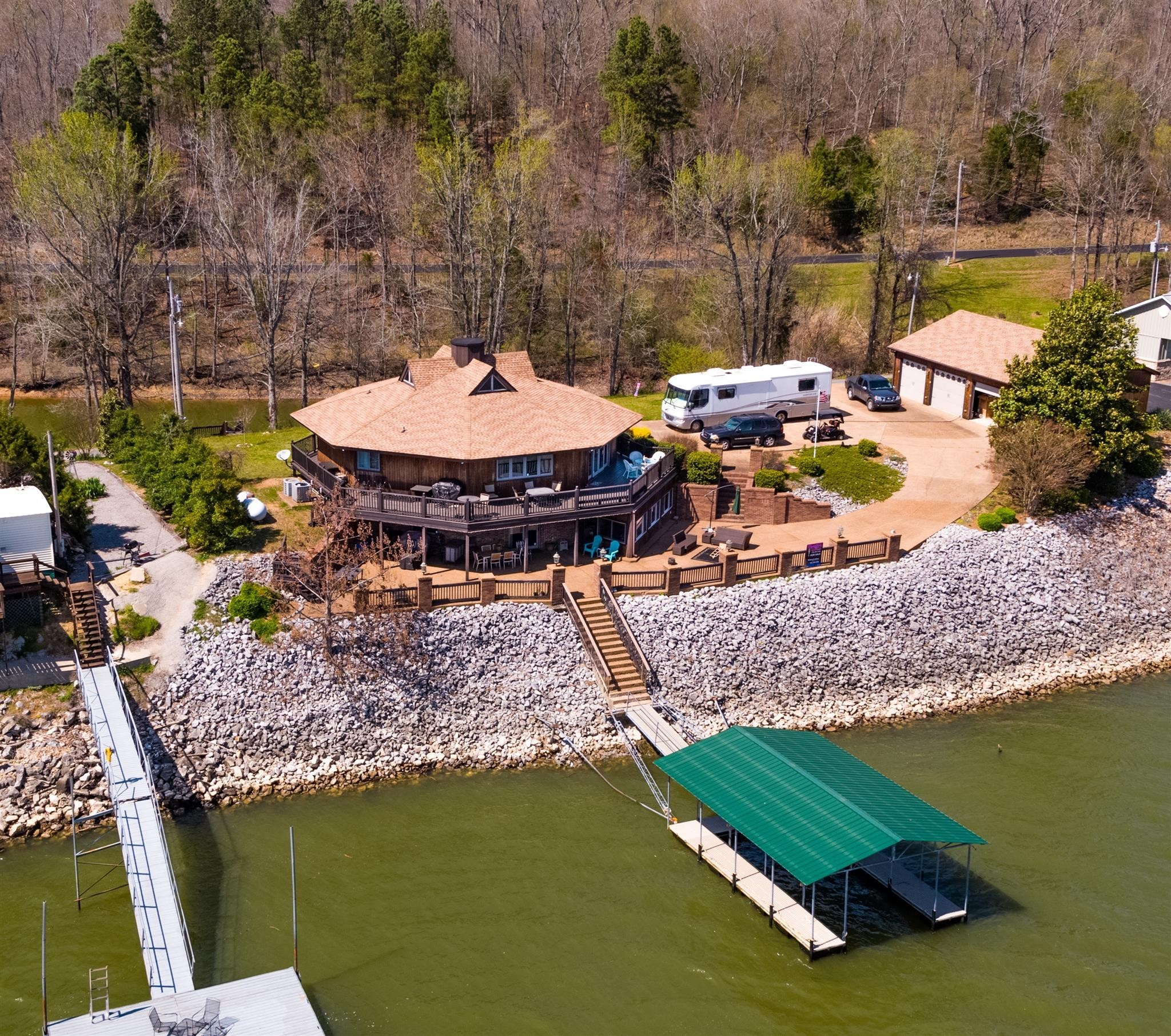 BEAUTIFUL CUSTOM HOME ON KY LAKE. DOUBLE LOT WITH 40X30 3 CAR GARAGE, COVERED BOAT DOCK, AGGREGATE DRIVE AND COVERED PATIO, WRAP-AROUND DECK AND ONLY 500 YARDS FROM 3 LANE BOAT RAMP. GATHERING ROOM WITH 2 WAY GAS FIREPLACE, FORMAL DINING ROOM PLUS BIG EAT-IN KITCHEN WITH GRANITE, UPDATED STAINLESS STEEL APPLIANCES AND DOUBLE OVENS. HUGE MASTER SUITE. MEDIA ROOM, BILLIARD ROOM, OFICE AND SEPARATE DEN. CLICK ON PHOTO TO VIEW DETAILED LIST OF FEATURES.